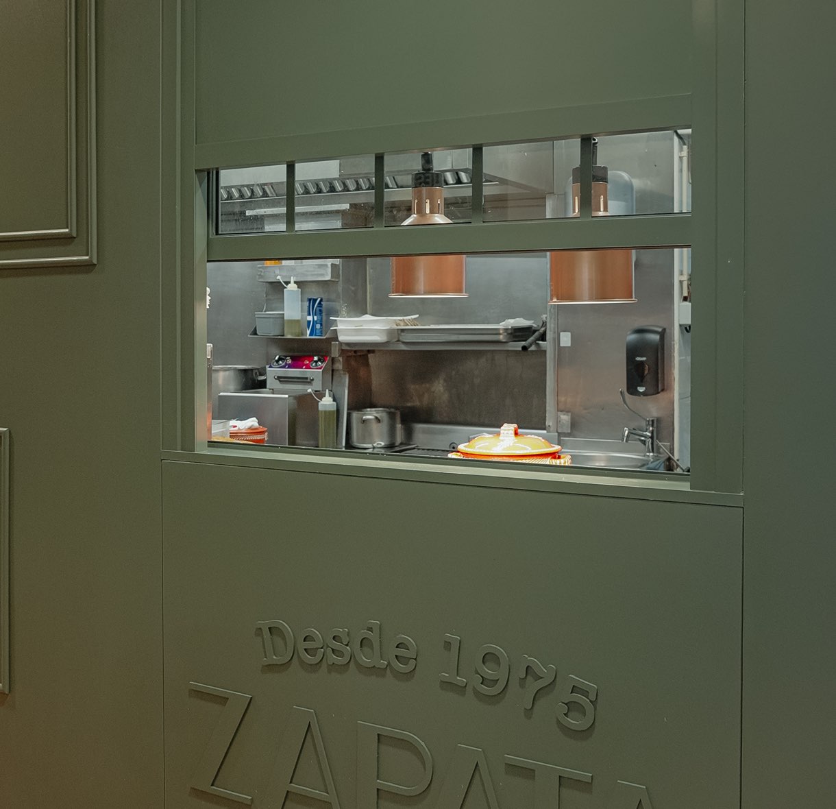 Kitchen window in the green wall with the Zapata logo