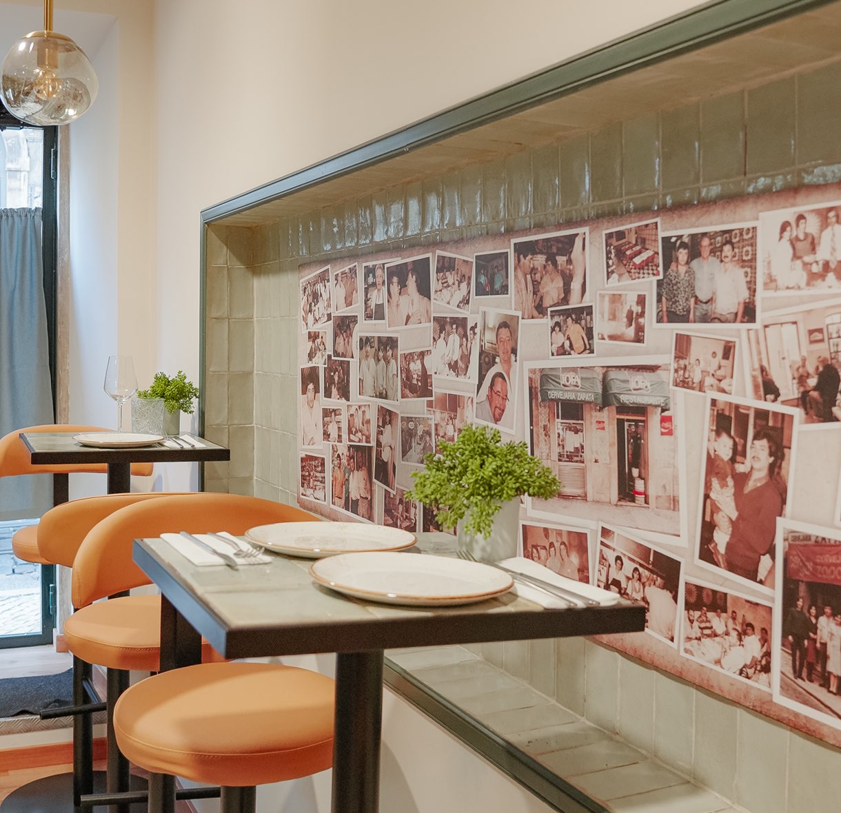 Dining room with set tables and a wall covered in family photographs